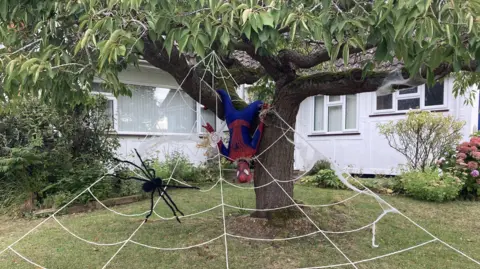 Luke Deal/BBC A Spiderman-themed scarecrow complete with a web and a large black spider