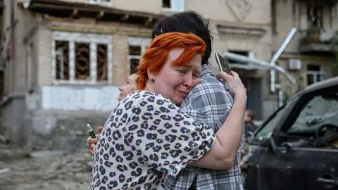 An explosion is seen after a Russian drone strikes a building as Ukrainian firefighters battle a fire in another building previously hit by a drone during a Russian air attack on Kyiv,