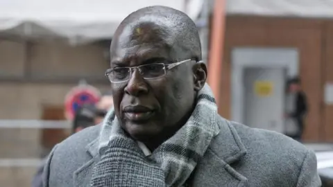 Former Nigeria’s petroleum minister Timipre Sylva wearing a coat, neck scarf and glasses