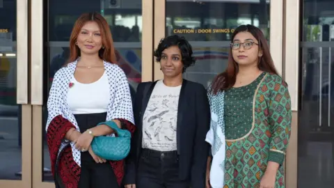 Three women standing outside of a court building