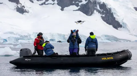 Paul Fahy/WWF A scientist on a small, inflatable research boat prepares to catch a drone in Antarctica
