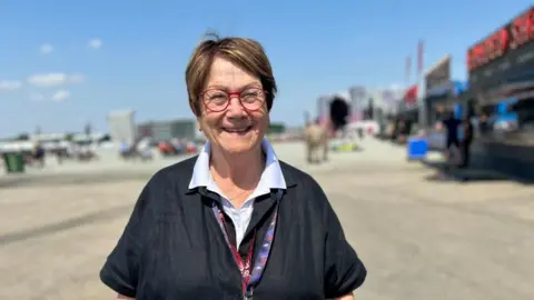 Kate Bradbrook/BBC Andrea Coleman with short dark hair in the Silverstone pits