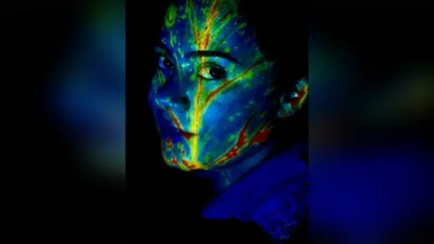 Women of the World/Saghar A women's face with yellow and red leaves superimposed over the top.