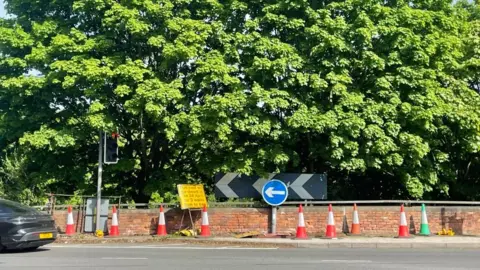 An image of QMC roundabout with traffic cones lined along it and a sign saying that there will be roadworks.