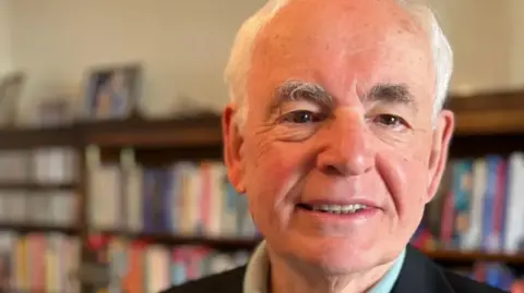 Stuart Woodward/BBC Professor Paul Whiteley is in what appears to be his office. We can see a bookcase behind him.