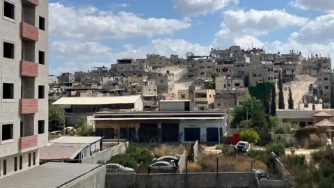 'Israeli forces took over my home and then they set it on fire' Empty buildings and bulldozer-created roads are seen in the distance
