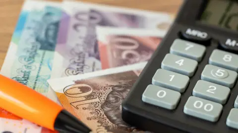 Pound notes, a pen and a calculator