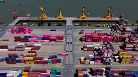 Xiqing Wang/ BBC Cambodia's port terminal shows pink and yellow containers