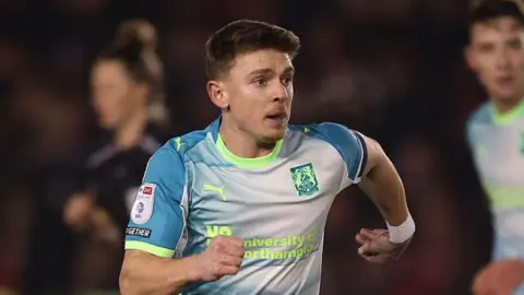 Sam Hoskins in a light blue Northampton Town shirt