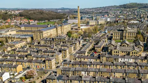 Light-stone coloured terraced houses and mills seen from above.