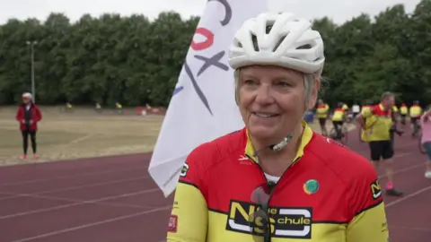 Sally from Ilkley Cycling Club at Cleckheaton in West Yorkshire ahead of the 11th Jo Cox Way bike ride in 2026. She has blonde hair and is wearing a white cycling helmet with a red and yellow cycling top.