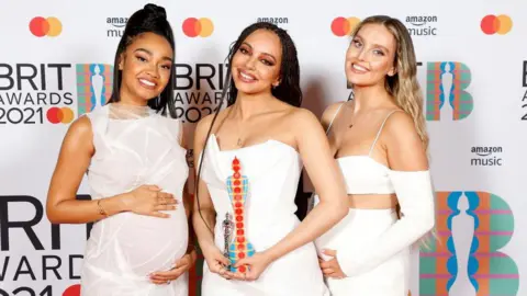 Getty Images Leigh-Anne Pinnock, Jade Thirlwall and Perrie Edwards of Little Mix pose with their British Group award in the media room during The BRIT Awards 2021 at The O2 Arena on May 11, 2021 in London