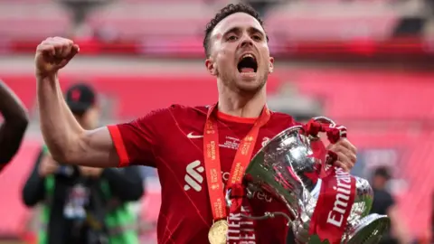 Diogo Jota celebrates with the FA Cup trophy following Liverpool's win over Chelsea in 2022