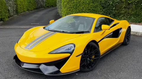 Gareth Edwards A yellow Mclaren sports car in a drive with a circle close up of the damaged bonnet
