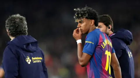 Lamine Yamal walks off the pitch, hand to his mouth, looking disappointed