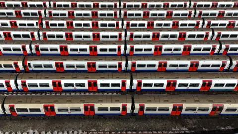 Line of Tube trains parked at depot.