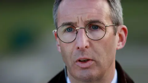 PA Media Andrew Muir. He has short grey-ish hair, wearing glasses and a brown jacket.