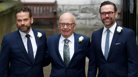 Rupert Murdoch poses for a photograph with his sons Lachlan (L) and James at his wedding to Jerry Hall in 2016