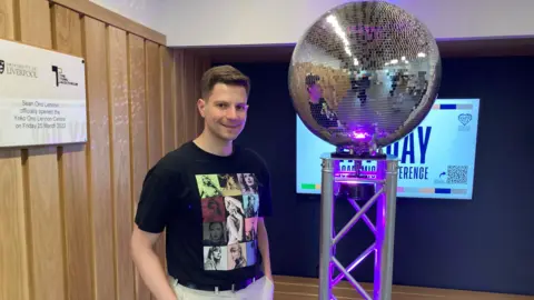 BBC Ross Michurin, from Russia, at the Tay Day, standing next to a disco ball