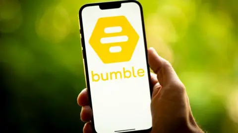 A generic image of a hand holding a smartphone with the Bumble symbol