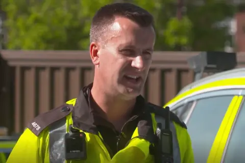 PC Richard Woodward, with short cut greying hair, in uniform
