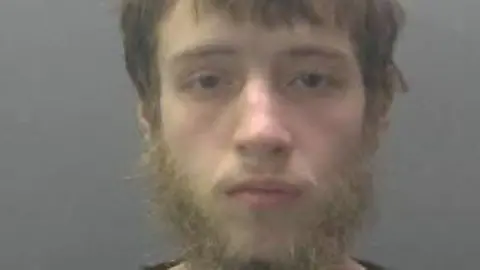 Cambridgeshire Police Joshua Turner with a beard looks directly to the camera