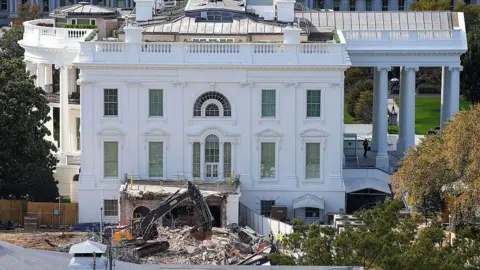The White House with a wrecker machine out front, on a pile of rubble