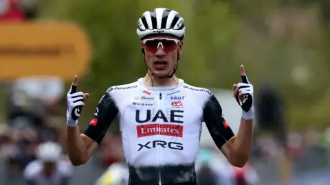 Juan Ayuso points to the sky as he celebrates victory at the seventh stage of the Giro d'Italia