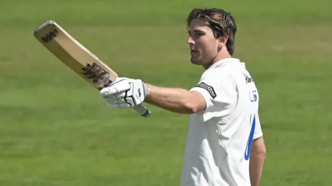 James Coles raises his bat against Glamorgan