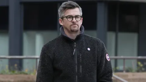 PA Media Joey Barton outside Liverpool Crown Court in a fleece and glasses. 