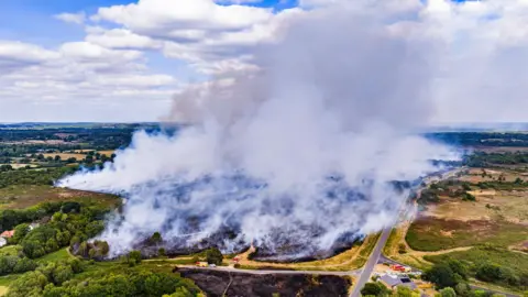 Lewis Johnstone Photography White plumes of smoke swirling into the sky, fields a seen in the foreground.