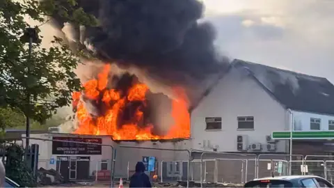 Daniel Byron/PA Wire fierce flames and black smoke rise from a white painted building