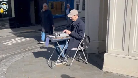 A man sitting by a typewriter in York city centre