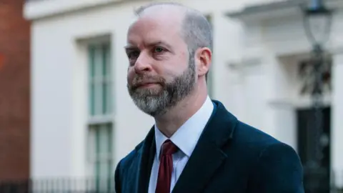 Getty Images Jonathan Reynolds, business secretary for the UK government, wearing a dark coat and a dark red tie.