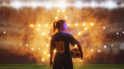 A female football player holding a football in front of bright lights