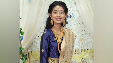 Family Sudiksha Thirumalesh in a blue dress and gold jewellery