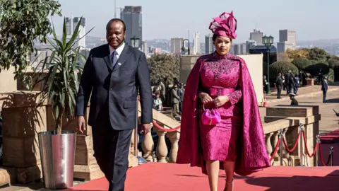 Per-Anders Pettersson/Getty Images  Eswatini King Mswati III arrives with his spouse to the presidential inauguration ceremony at Union Buildings on June 19, 2024, in Tshwane, South Africa. The African National Congress (ANC) party was forced to form a coalition government after failing to receive a majority vote in the recent general election. President Ramaphosa was sworn in as the president for South Africa by Chief Justice Raymond Zondo in the Nelson Mandela Amphitheatre. 