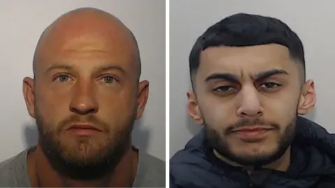 Morgan (left) has a bald head and a short beard, he wears a grey T-shirt. Shazad has short dark hair an a short dark beard. He wears a dark blue jacket