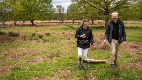 BBC/Emma Lynch James Gallagher and researcher Sally hunting for ticks