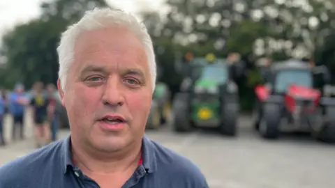 Farmer Mark Weekes standing in front of tractors