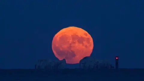 BBC Weather Watcher JDP-M Full strawberry moon rising over the needles on the Isle of Wight.