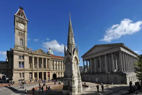 General view of Chamberlain Square in Birmingham. On the left can be seen the Birmingham City Museum & Art Gallery and on the right can be seen the Town Hall. In the foreground can be seen the Chamberlain Memorial.