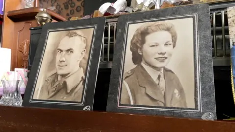 Two black and white, sepia photos of a man and woman in military uniform. The pictures look old.