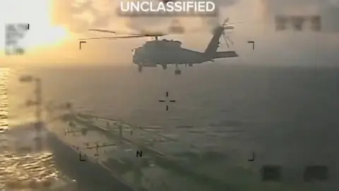 A US helicopter is seen flying over an oil tanker.