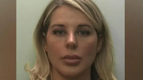 Devon and Cornwall Police Mugshot of a blonde woman who is staring straight into the camera.