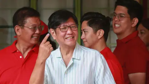 Getty Images Philippine President Ferdinand Marcos shows his inked finger after voting in the mid-term election at a polling station in Batac town, Ilocos Norte province on May 12, 2025.