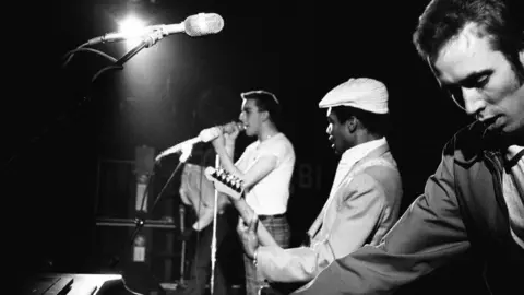 A black and white photograph of The Specials performing on stage.