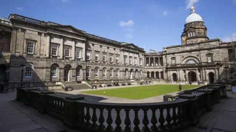 PA Media An exterior view of the University of Edinburgh's Old College building on a sunny day. 
