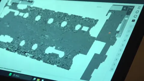 A view of a computer screen showing the grey shape of a cathedral floor plan on a light-blue background.