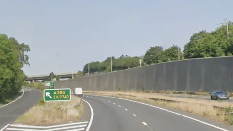 Google image of A38 near Manadon in Plymouth. A van is travelling along the carriageway.